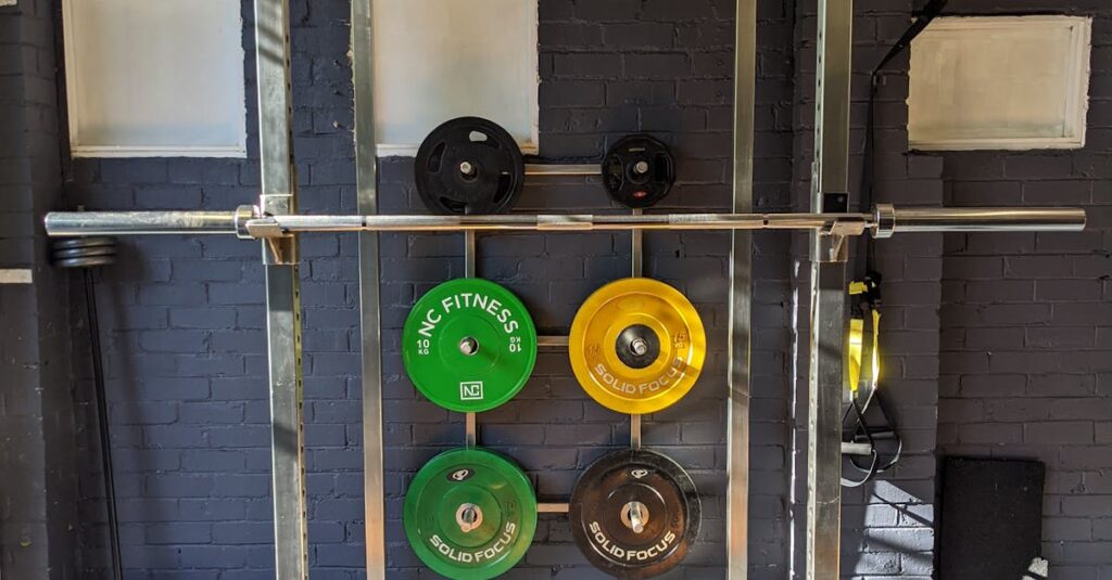 A well-equipped home gym featuring a squat rack, weights, and a bench.